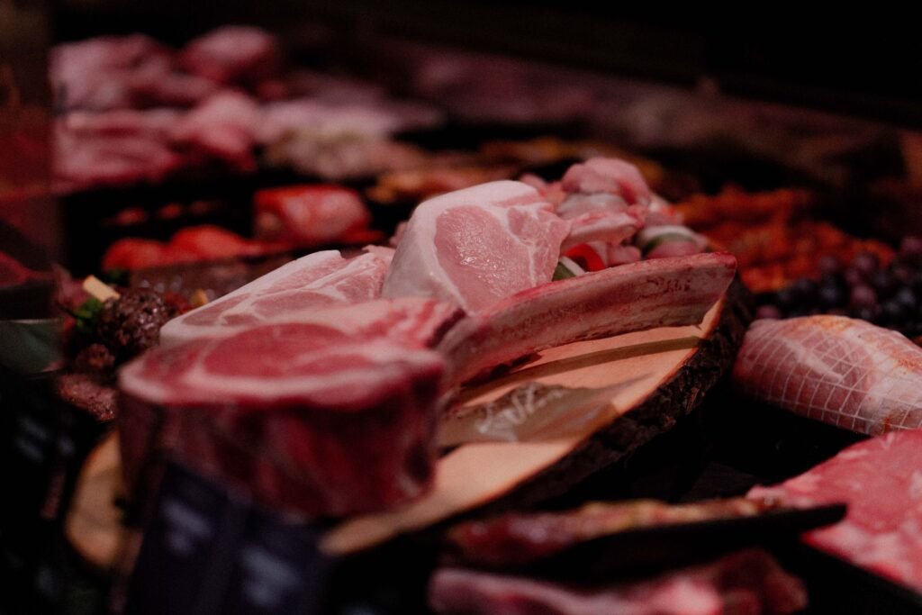 Fresh raw meat cuts on a wooden tray at a butchery